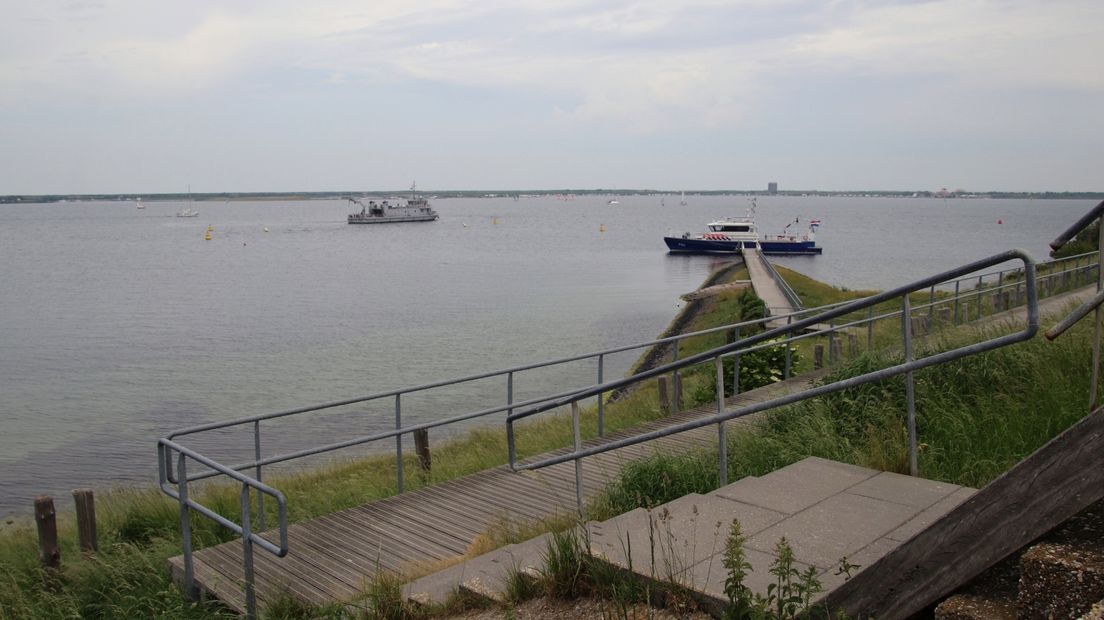 Politievaartuig en duikersvaartuig van de marine in haven van Scharendijke na vermissing duikers