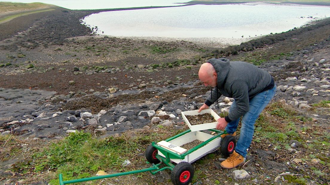 Met twee zeven scheidt Arnold Fluijt de plastic korrels van zand en zeewier