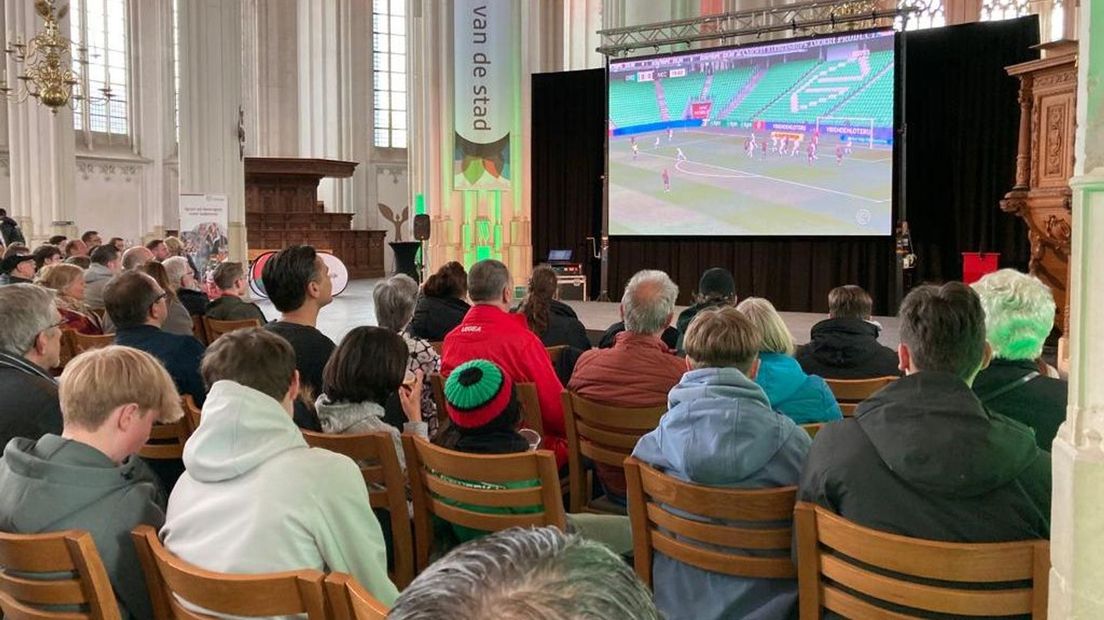NEC-supporters kijken de wedstrijd in de St. Stevenskerk.
