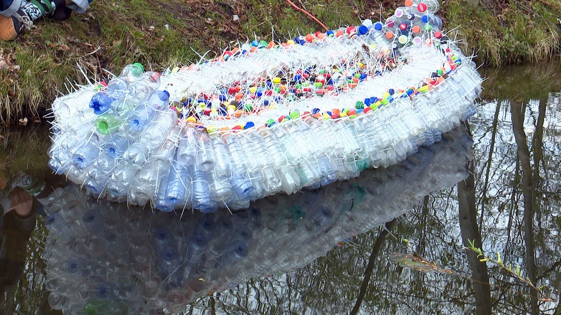 De kano gemaakt van gevonden plastic flessen , geschikt om mee weg te vluchten als het water te hoog mocht komen door de klimaatverandering.