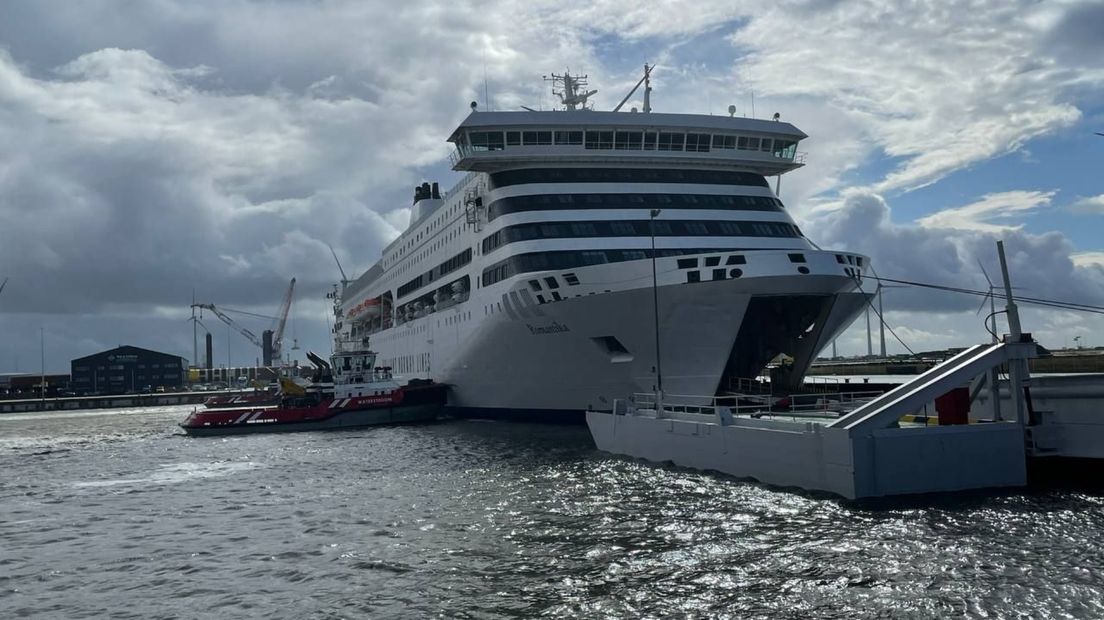 MS Romantika wordt in de Eemshaven door twee sleepboten op z'n plaats gehouden