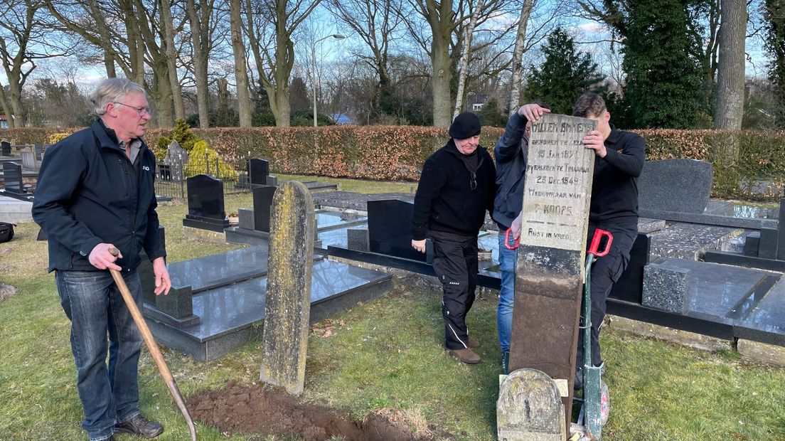 De grafzerk wordt onder toeziend oog van achterkleinzoon Jan Emmens (links) uit de grond gespit