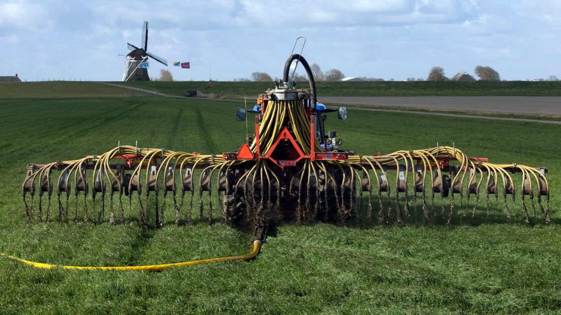 Een boer rijdt mest uit over zijn land bij de Eemshaven