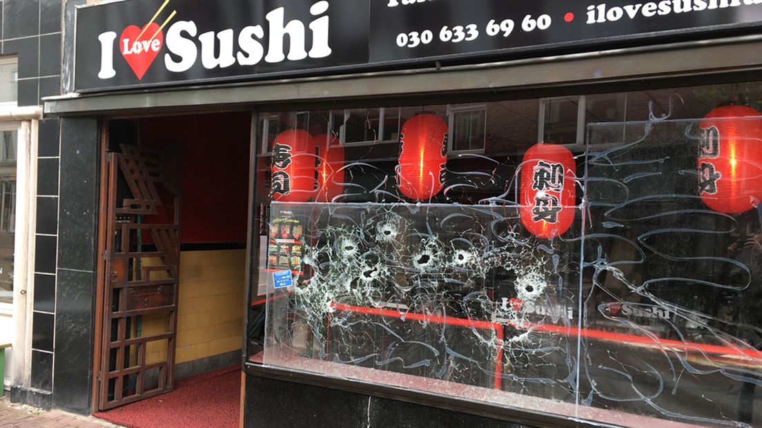 In de ruit van de sushibar zijn flinke kogelgaten te zien.