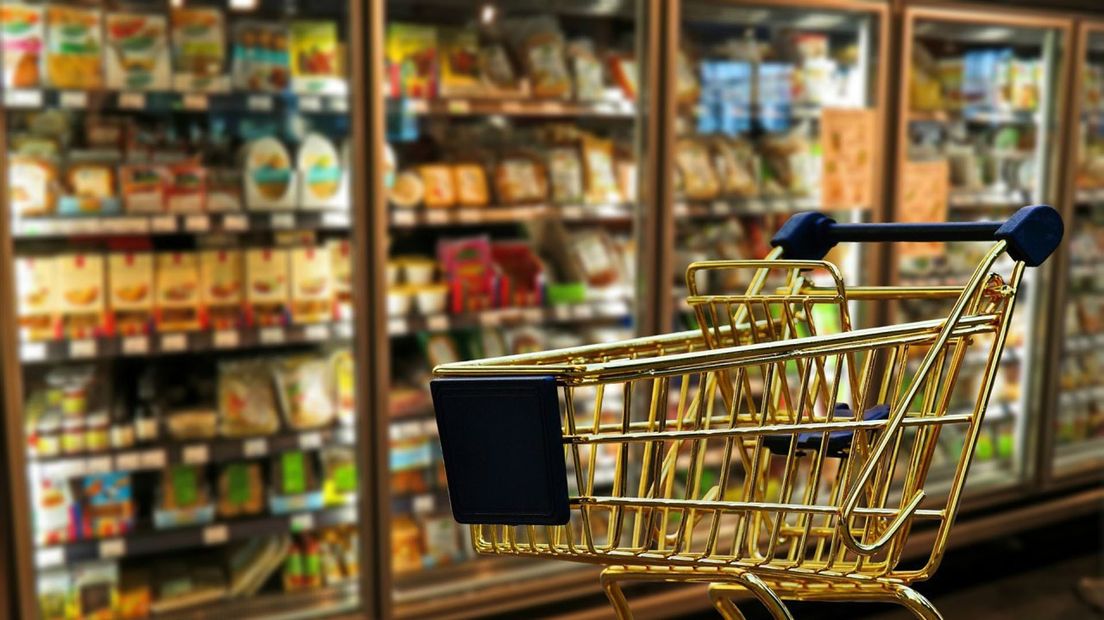 Een winkelwagen middenin van een supermarkt.