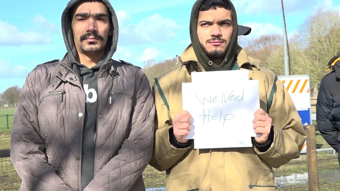 Twee asielzoekers tonen een protestbord