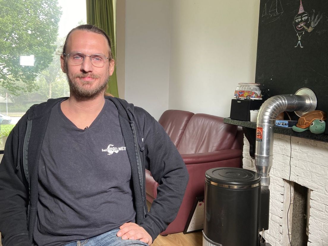 Vincent Schotel naast zijn kachel die deze winter waarschijnlijk niet zal branden