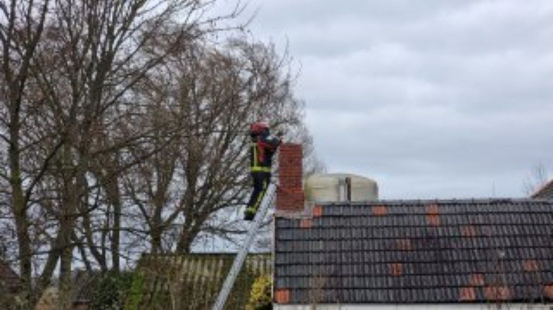 Een brandweerman kijkt in de schoorsteen