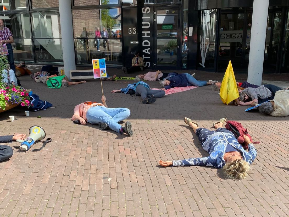 Klimaatactivisten van Extinction Rebellion vallen dood neer voor het gemeentehuis in Assen.