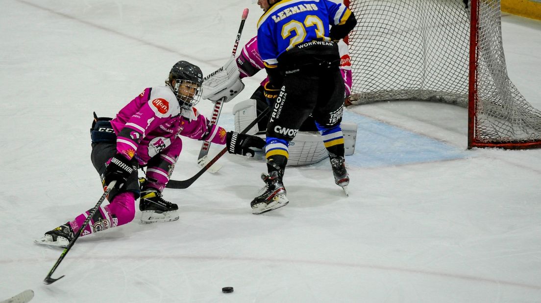 GIJS-speler Thomas Krukowski, in het roze shirt, gaat er met de puck vandoor