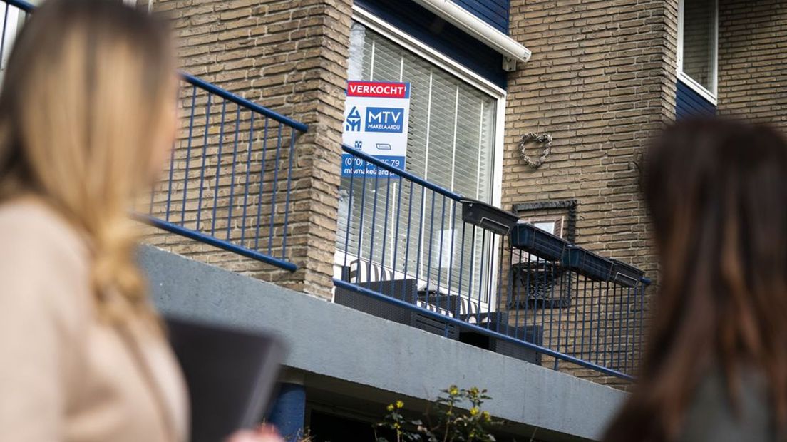 Een 'verkocht'-bord aan een woning.