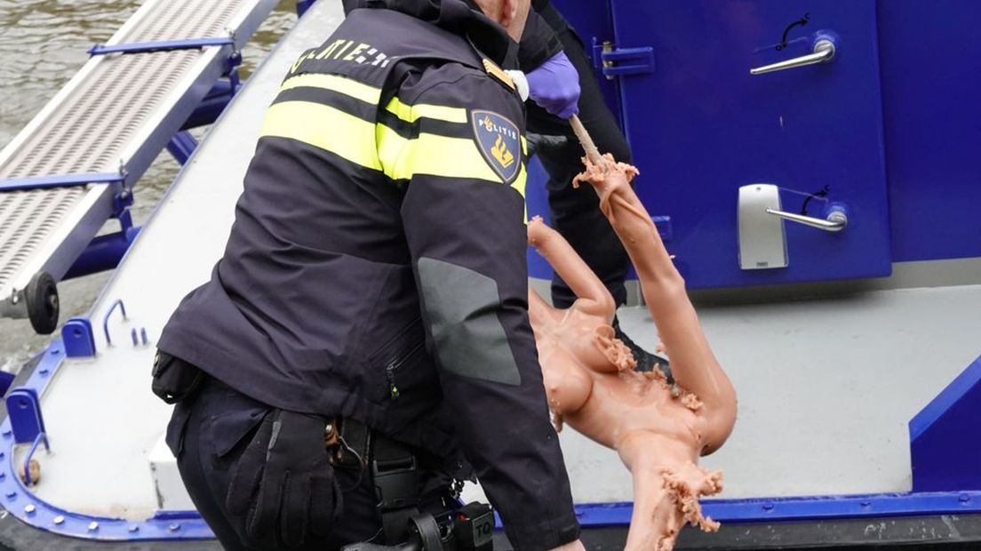 Een agent met de uit het water geviste sekspop.