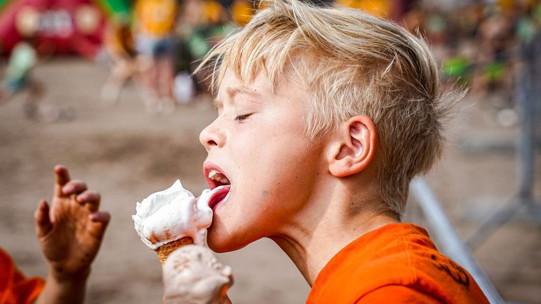 Jongen geniet van het mooie weer met een ijsje.