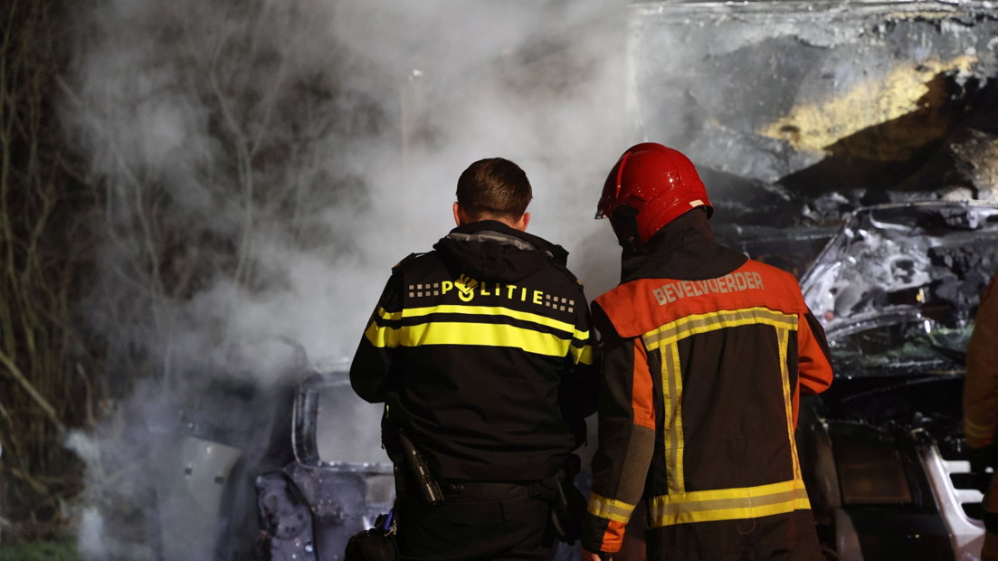Hulpverleners bij de uitgebrande auto's