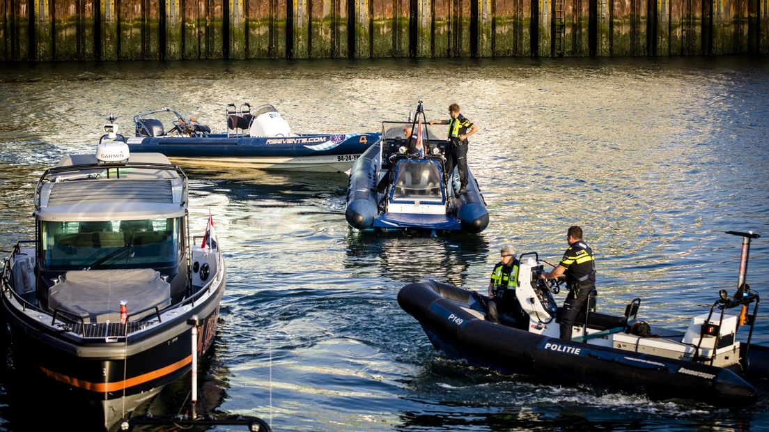 Hulpdiensten slepen de rubberboot weg na de aanvaring in de haven van Scheveningen.