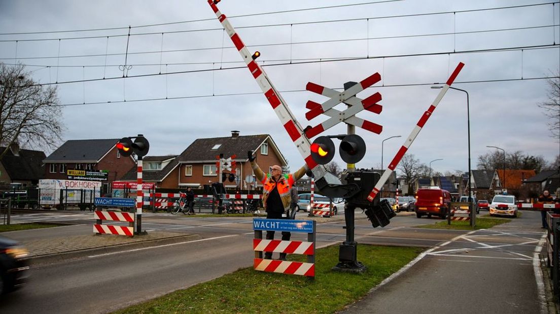 Medewerkers houden de spoorbomen handmatig open.