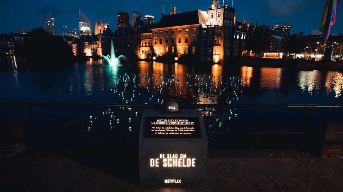 Honderden lichtgevende legerhelmen drijven in de Hofvijver