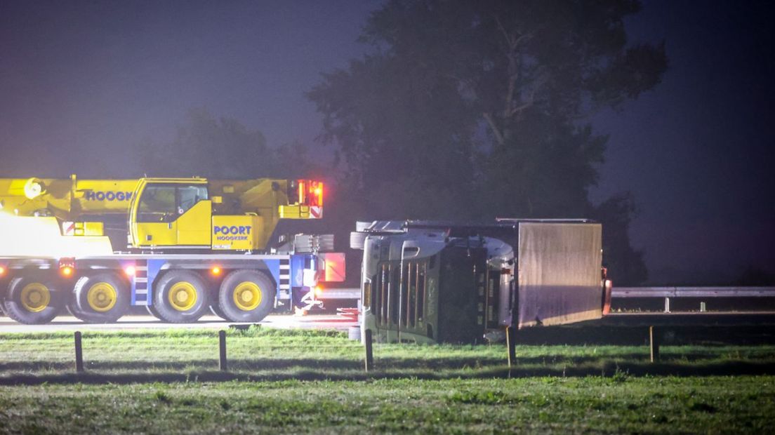 Een bergingsvoertuig bij de gekantelde vrachtwagen