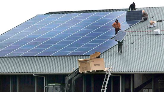 Mensen leggen zonnepanelen aan op een dak (ter illustratie)