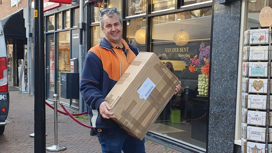 Pakketbezorger Kees Vlasveld aan het werk in de Schoolstraat