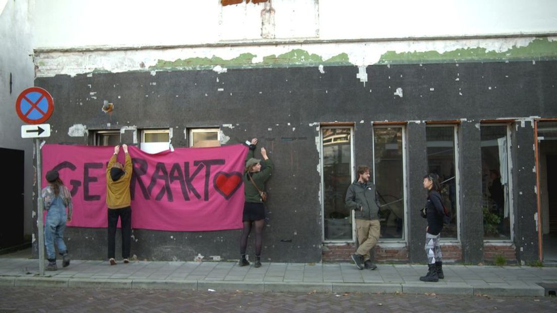 Aan de voorkant van het pand is een groot spandoek opgehangen