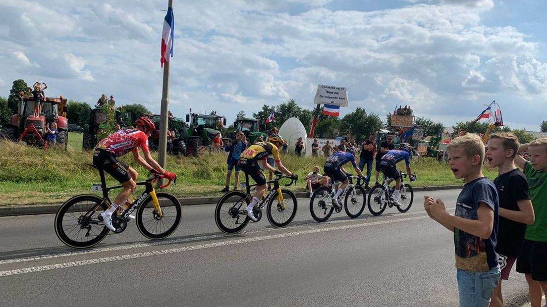 Robert Gesink rijdt in zijn rode leiderstrui langs de boeren