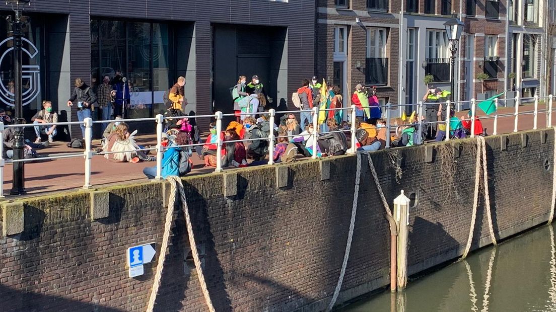 Op de Zeedijk zitten de demonstranten op de weg