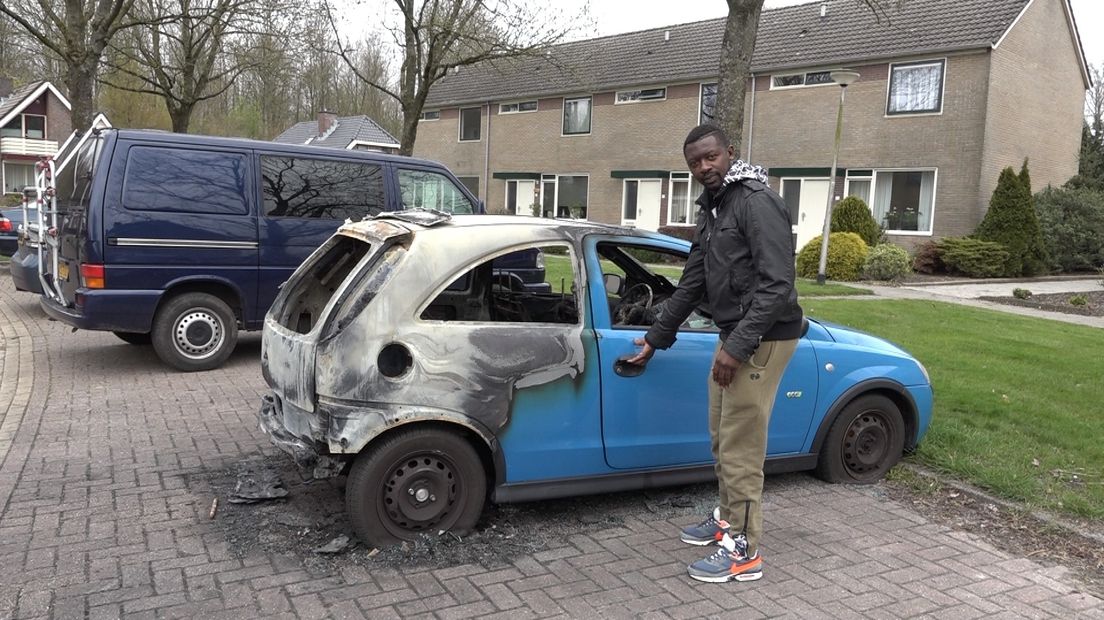 Pascal Fon laat beteuterd de staat van zijn afgebrande auto zien.