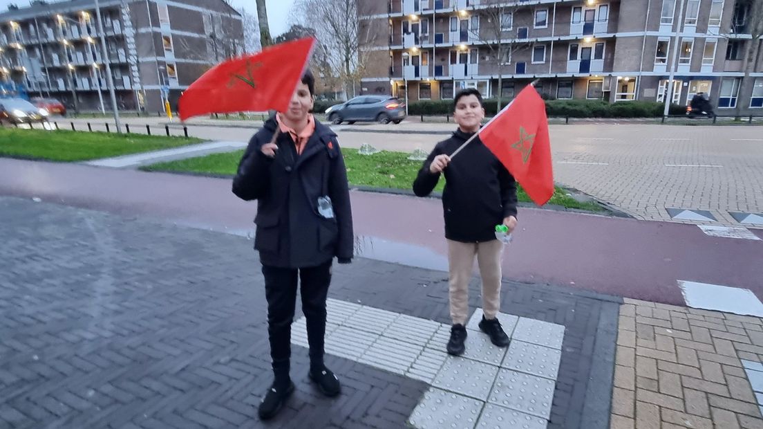 Blije kinderen zwaaien met een Marokkaanse vlag.