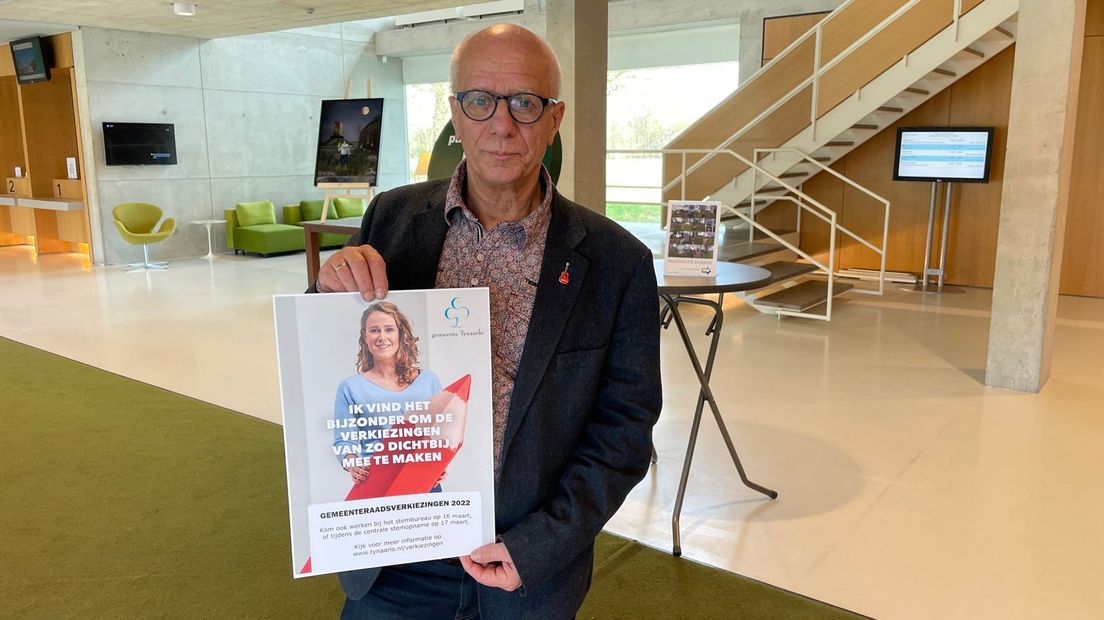 Stembureaulid Frits Colenbrander met een poster om meer leden te werven
