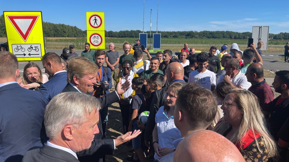 De koning praat buiten het aanmeldcentrum met medewerkers van hulporganisaties