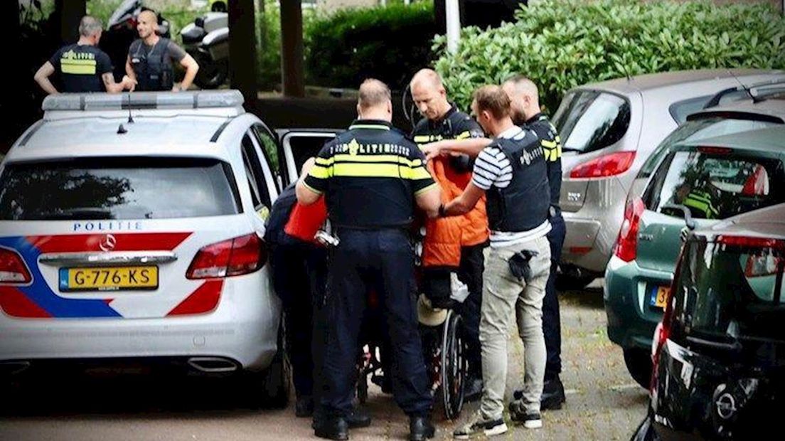 Verdachte van de ontvoering van een 5-jarig meisje in Glanerbrug wordt in een rolstoel afgevoerd.