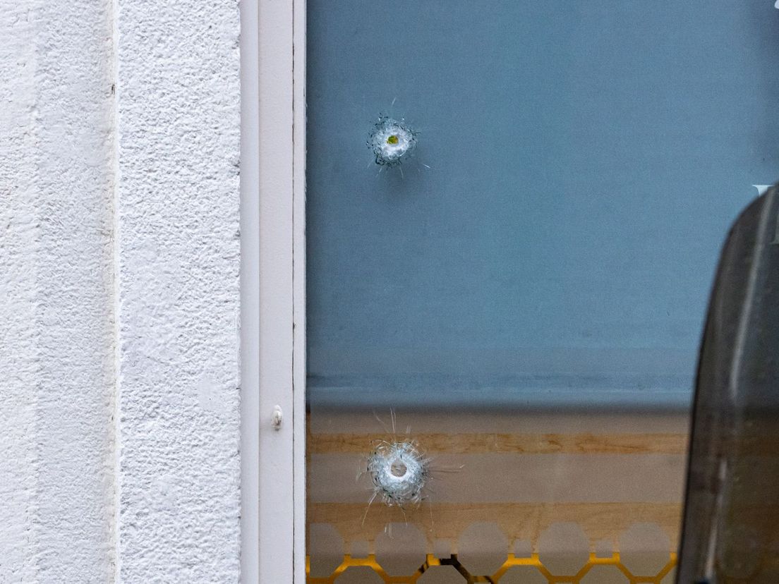 In de ramen van het beschoten restaurant zijn kogelinslagen te zien