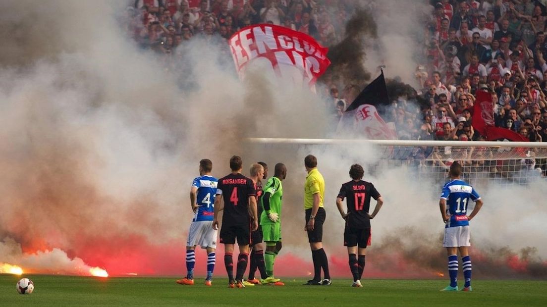 Ajax-supporters gooien vuurwerk op het veld
