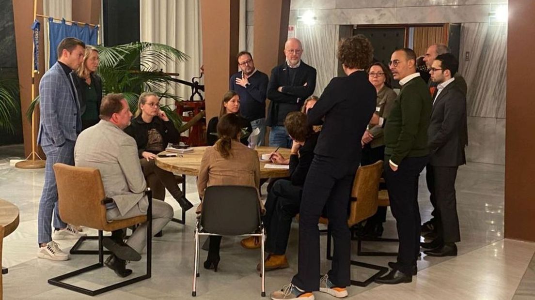 Partijen proberen tijdens een schorsing nader tot elkaar te komen in de ruimte naast de raadszaal.
