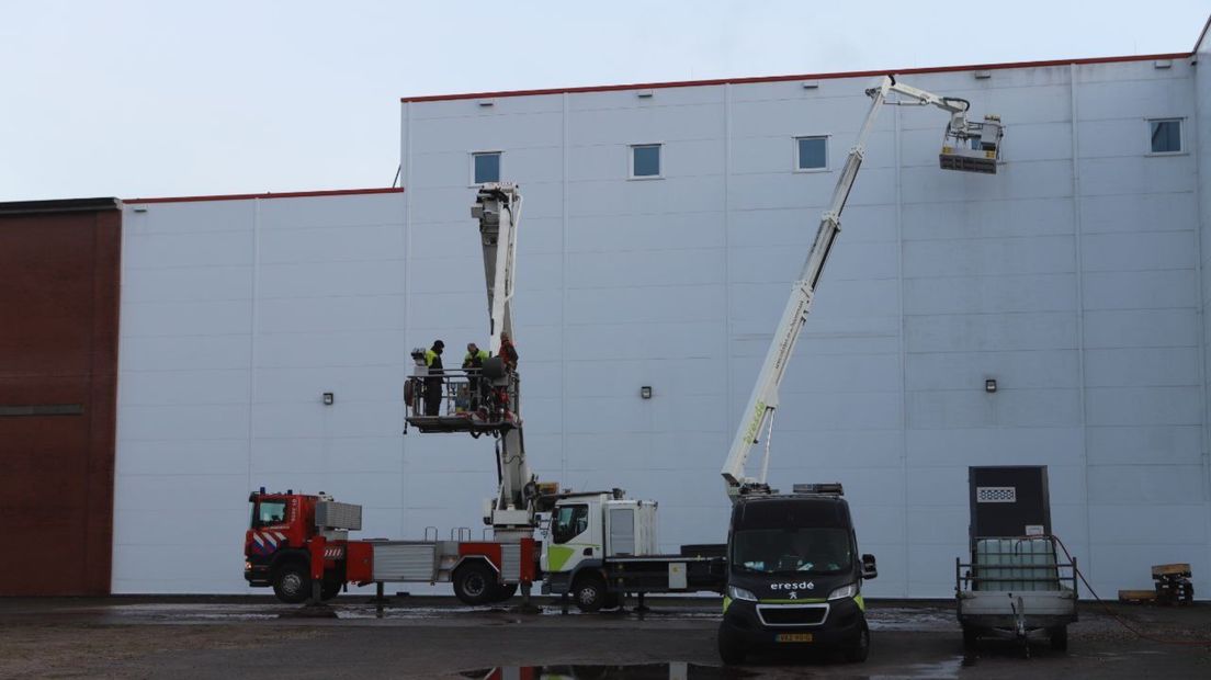 De hoogwerker van de brandweer (links) assisteert de in problemen geraakte hoogwerker