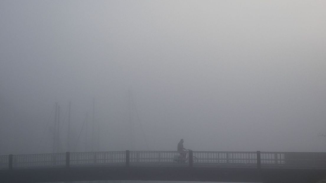 Man op fiets in mist bij Middelburg