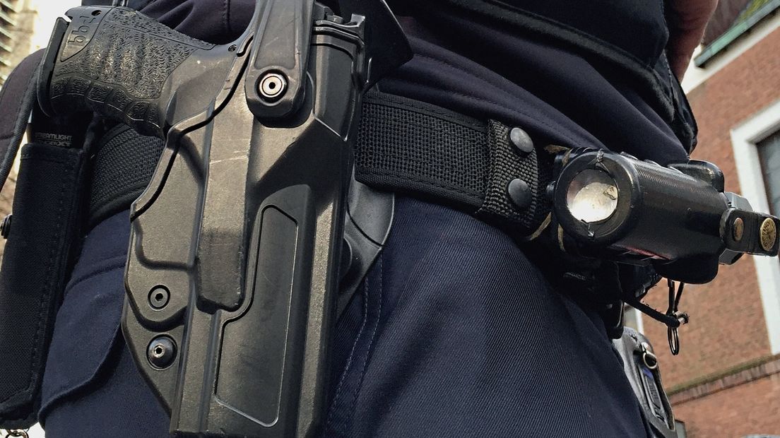 Vuurwapen en pepperspray aan broekriem agent