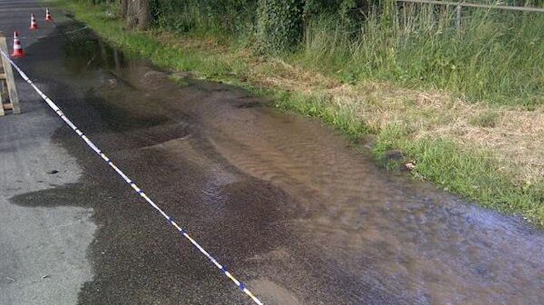 waterleiding gesprongen; deel van weg staat blank